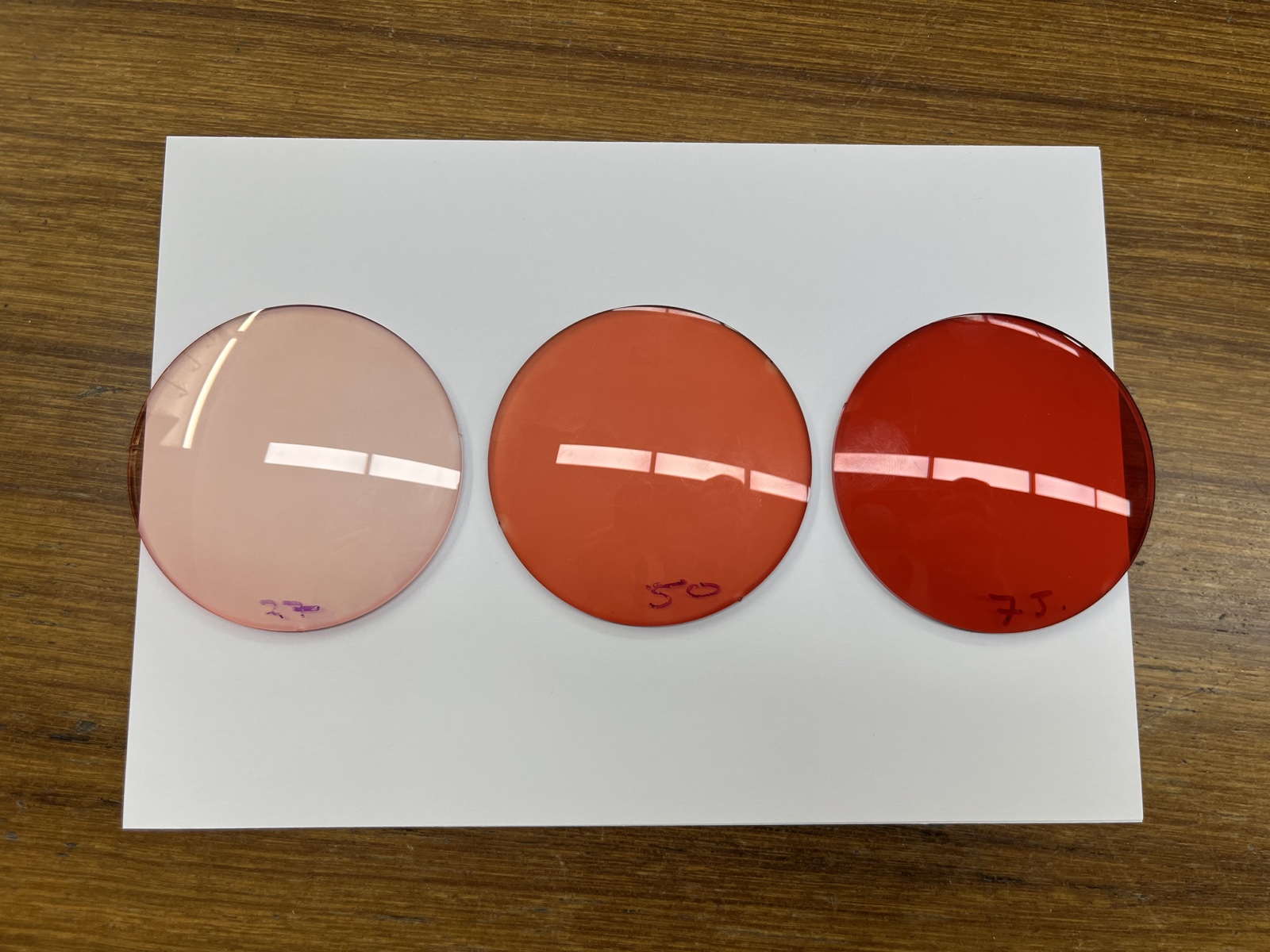Tint samples for FL-41 glasses on white paper, ranging from pale rose to deeper orange-red and red, with handwritten markings.